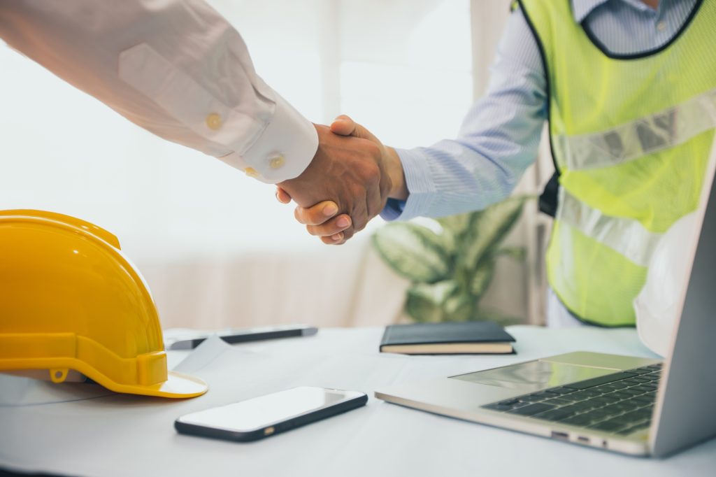 Handshake of builder, engineer with architecture after successful discussing and planning